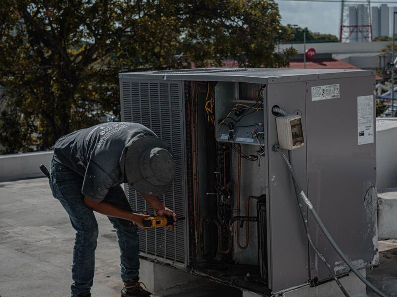HVAC technician servicing a rooftop air conditioning unit